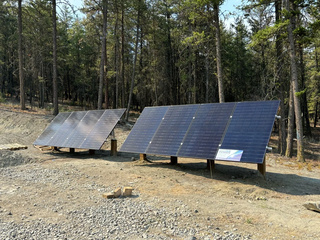 Two ground-mounted solar arrays in a forest clearing, in the project photograph supplied for the Solex cabin feature
